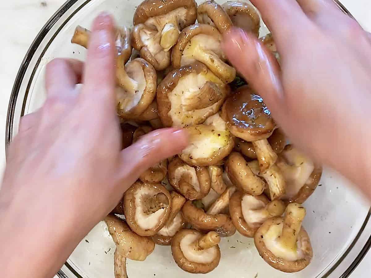 Coating the mushrooms in the olive oil mixture.