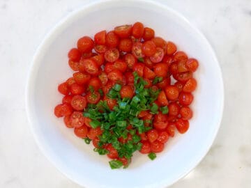 Tomatoes and scallions in a salad bowl.