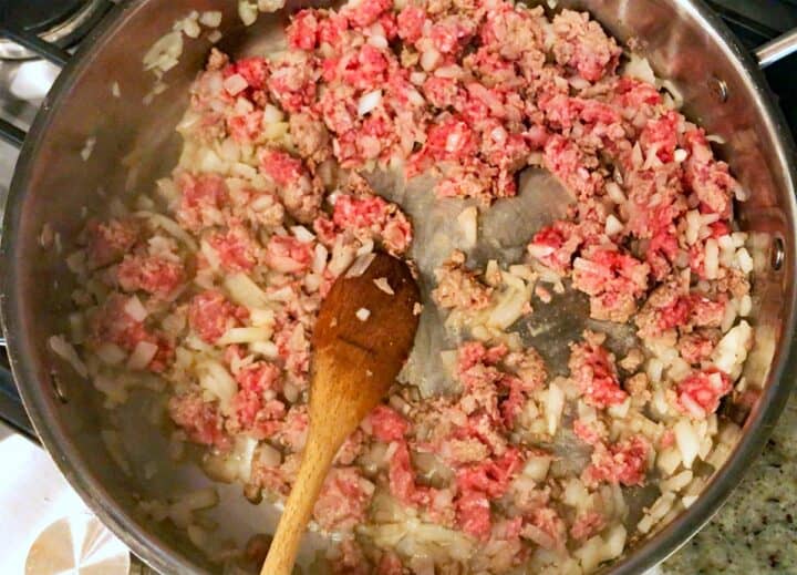 Cooking ground beef and onions in a skillet.