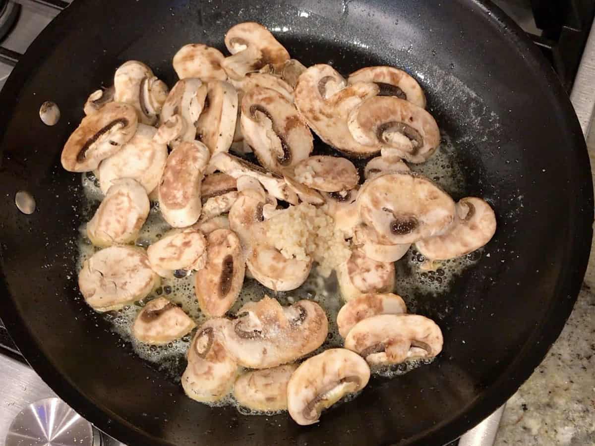 Cooking the mushrooms and garlic in a skillet.