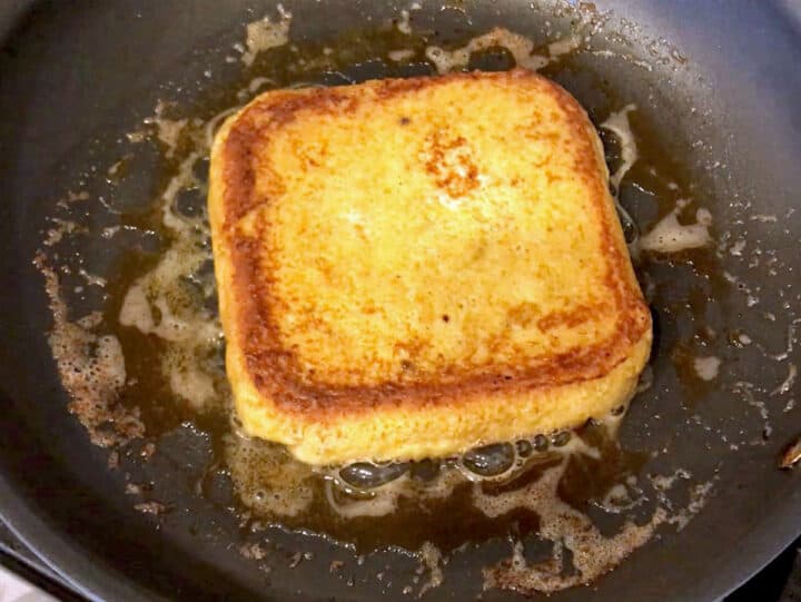 Cooking the French toast in a skillet.
