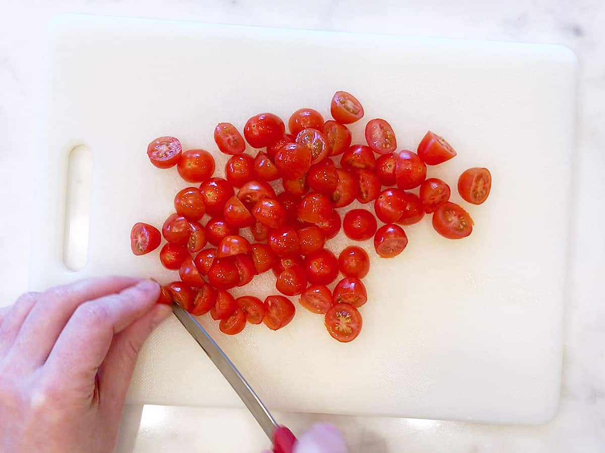 Cutting cherry tomatoes in half.