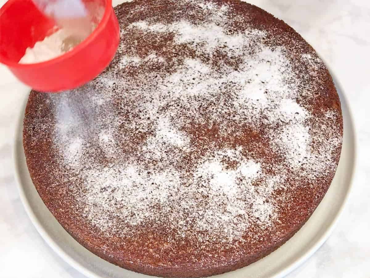 Dusting the cake with a powdered sweetener.