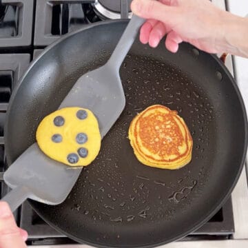 Flipping the pancakes in the skillet.
