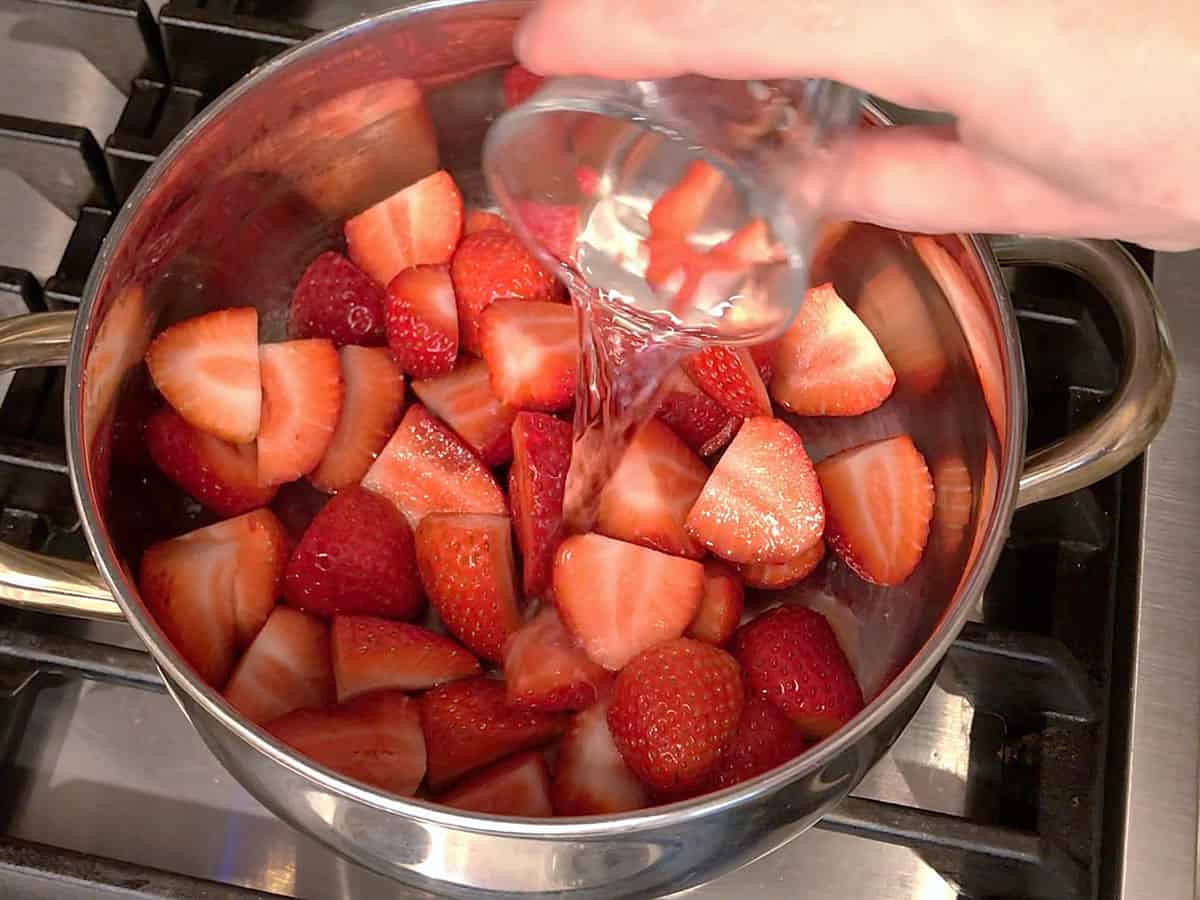 Adding the compote ingredients to a saucepan.