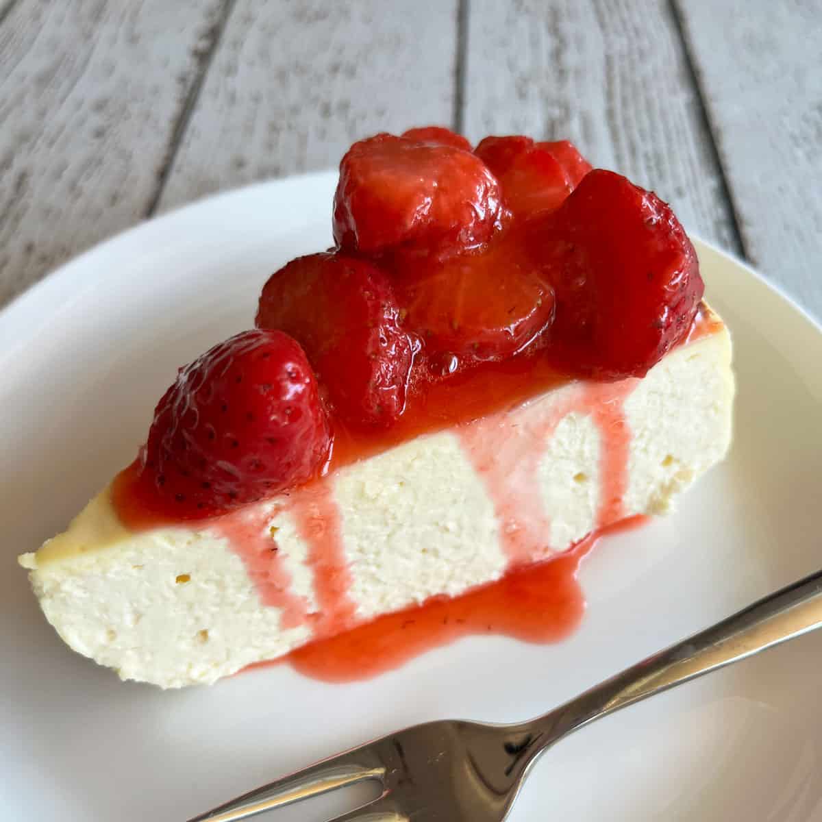A slice of keto cheesecake topped with strawberry compote.