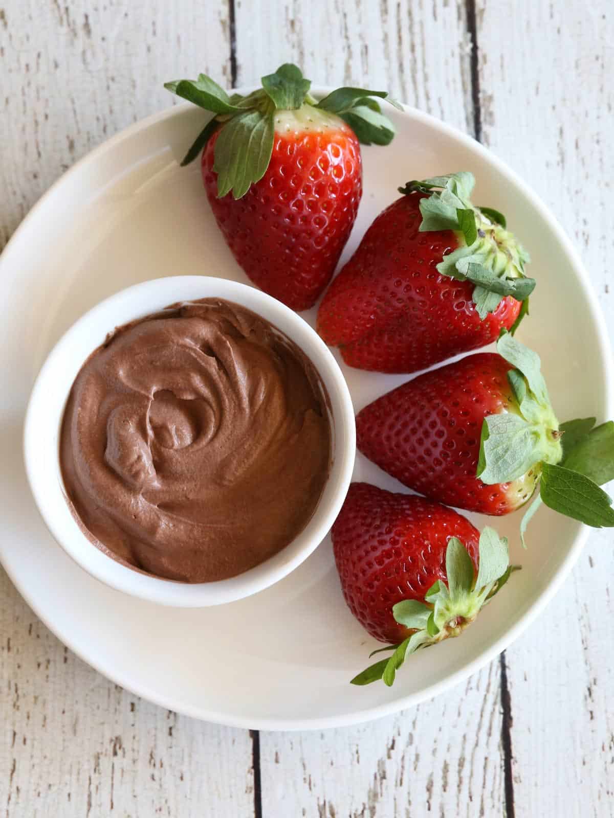 Keto chocolate mousse is served with strawberries.