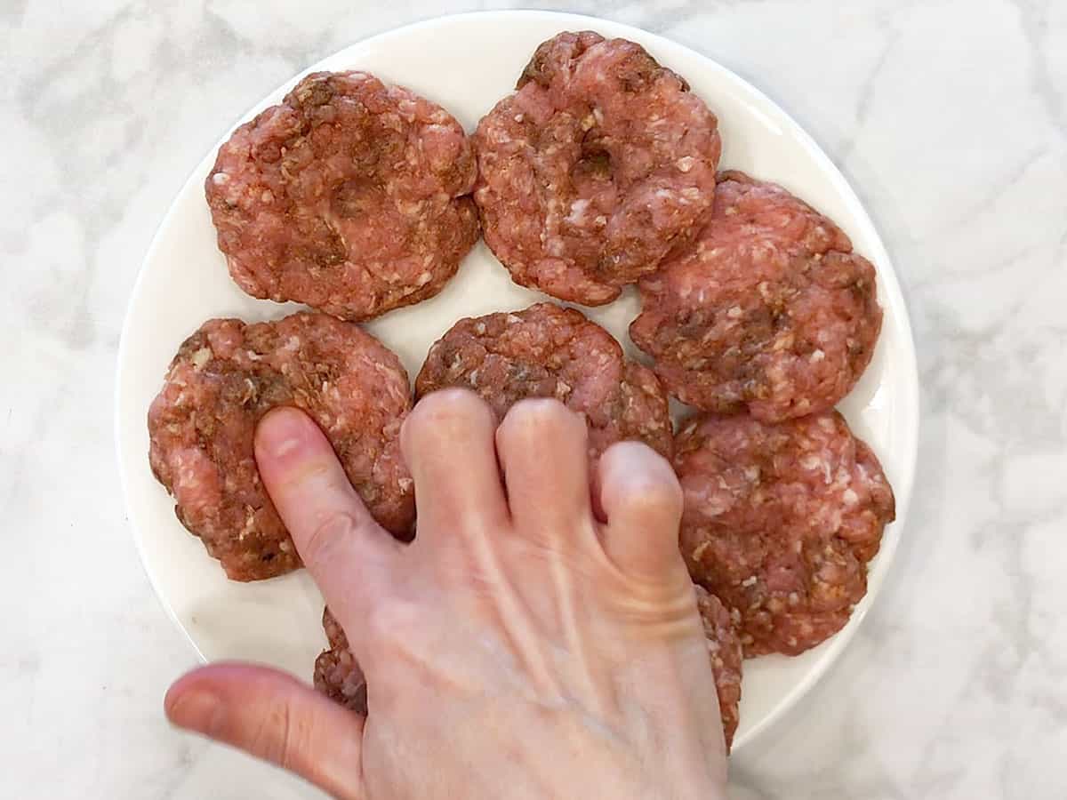 Making a dimple at the center of the sausage patties.