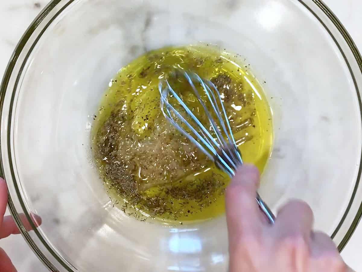 Mixing olive oil and spices in a bowl.