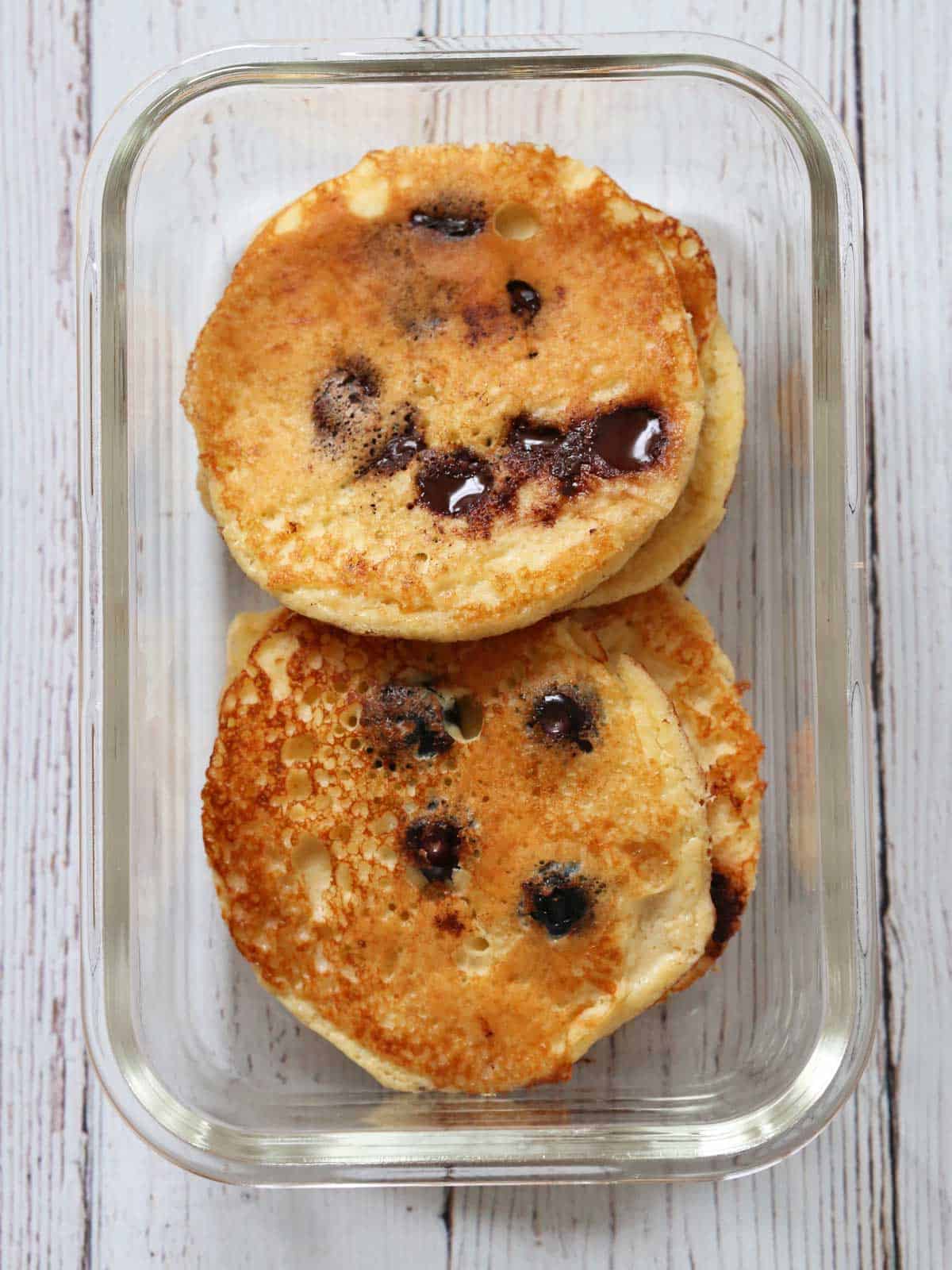 Leftover protein pancakes are stored in a glass food storage container.