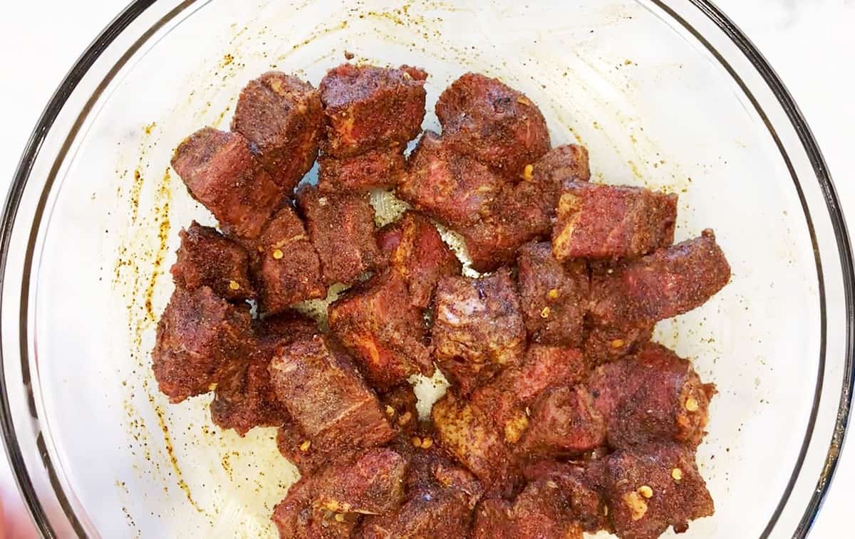 Seasoned beef cubes in a bowl.