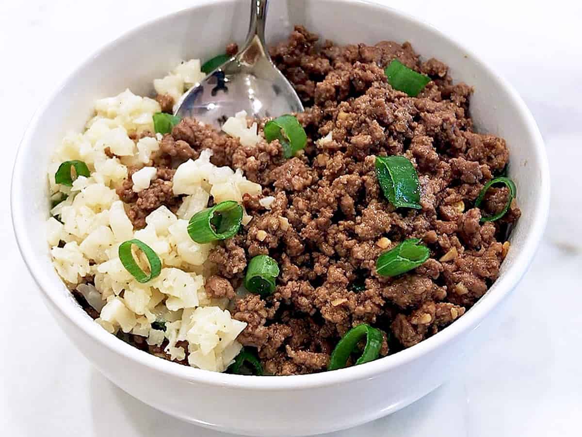 Korean ground beef is served, topped with sesame oil and scallions.
