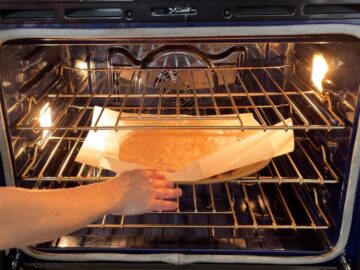 Placing the crust in the oven.