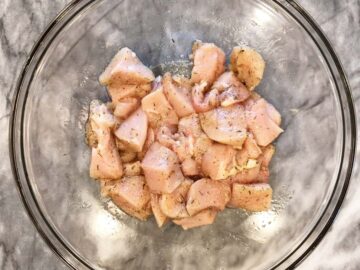 Seasoned chicken cubes in a bowl.