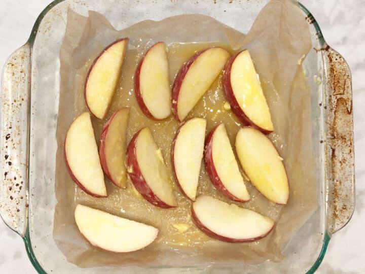 The apple slices are in the pan and coated with melted butter.