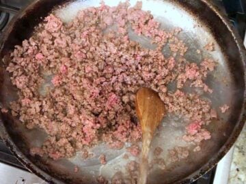 Cooking the ground beef in a large skillet.