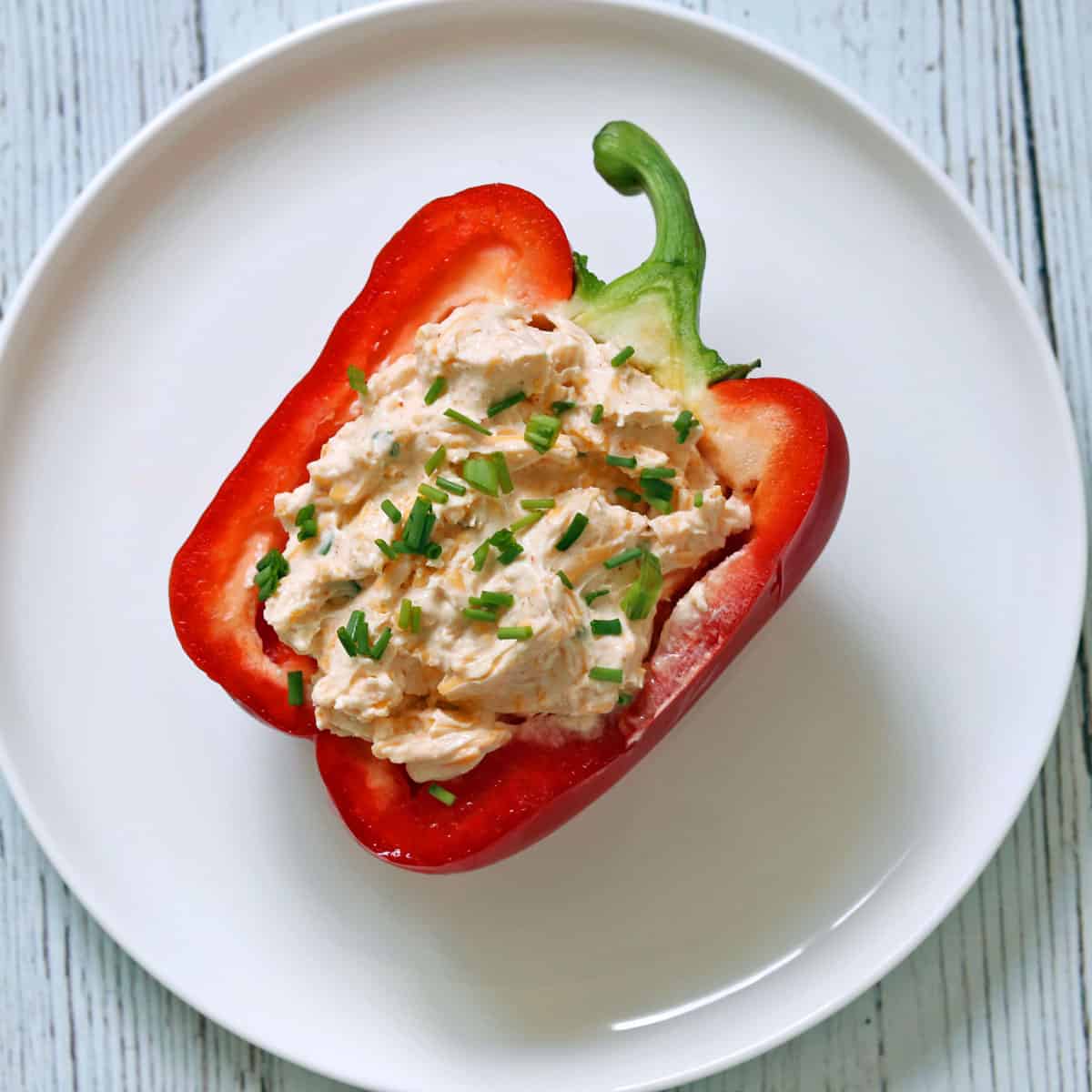 A halved bell pepper is stuffed with cream cheese dip.