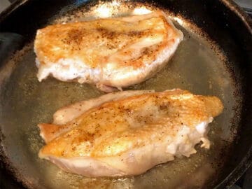 The chicken was flipped in the skillet.