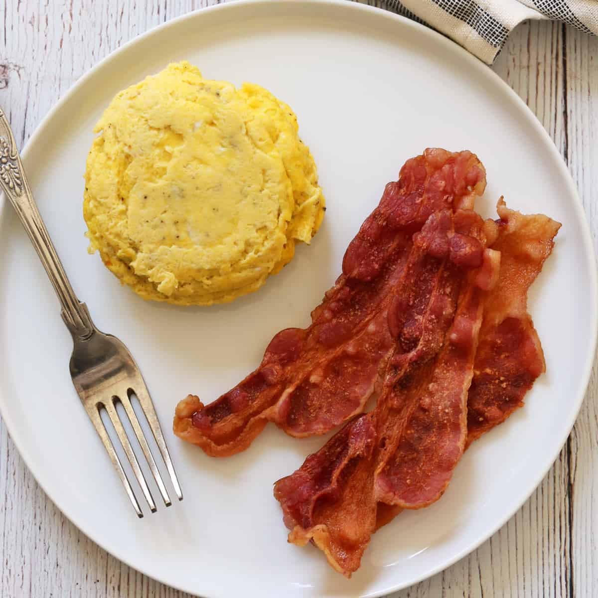 Microwave scrambled eggs are served with microwave bacon.
