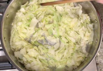 Mixing the butter and spices into the steamed cabbage.