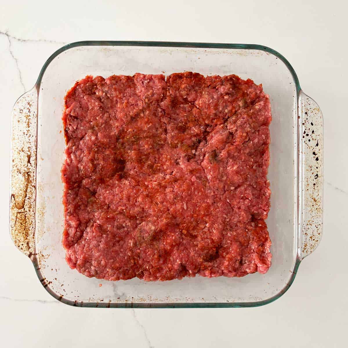 The beef mixture is in a square pan.