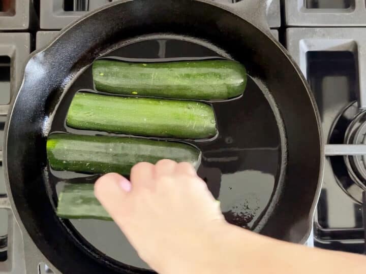 Placing the zucchini in the skillet.