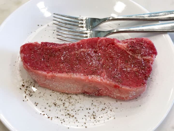 The steak is seasoned with salt and pepper.