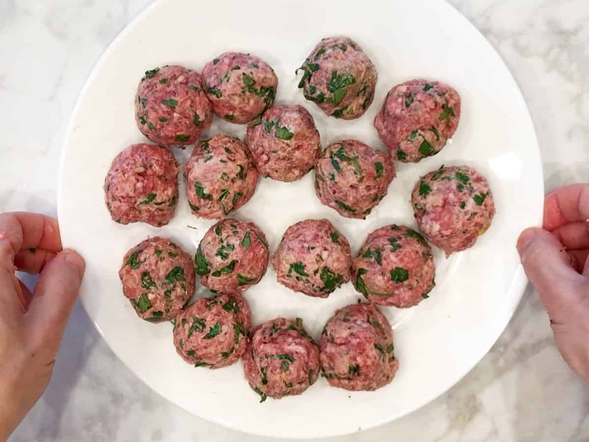 Raw lamb meatballs on a plate.