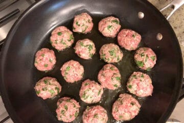 Cooking lamb meatballs in oil in a skillet.
