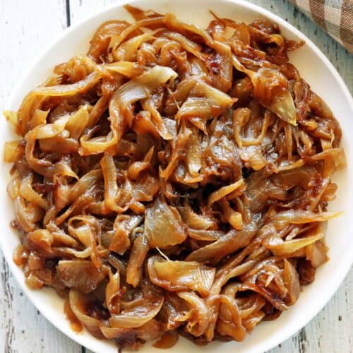 Caramelized onions served on a white plate with a napkin.
