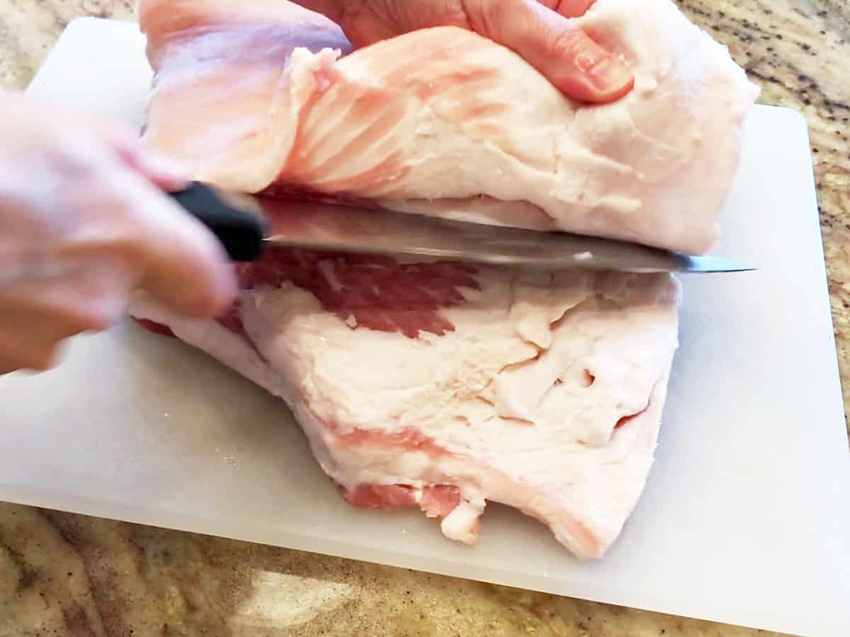 Cutting pork skin off the pork belly.