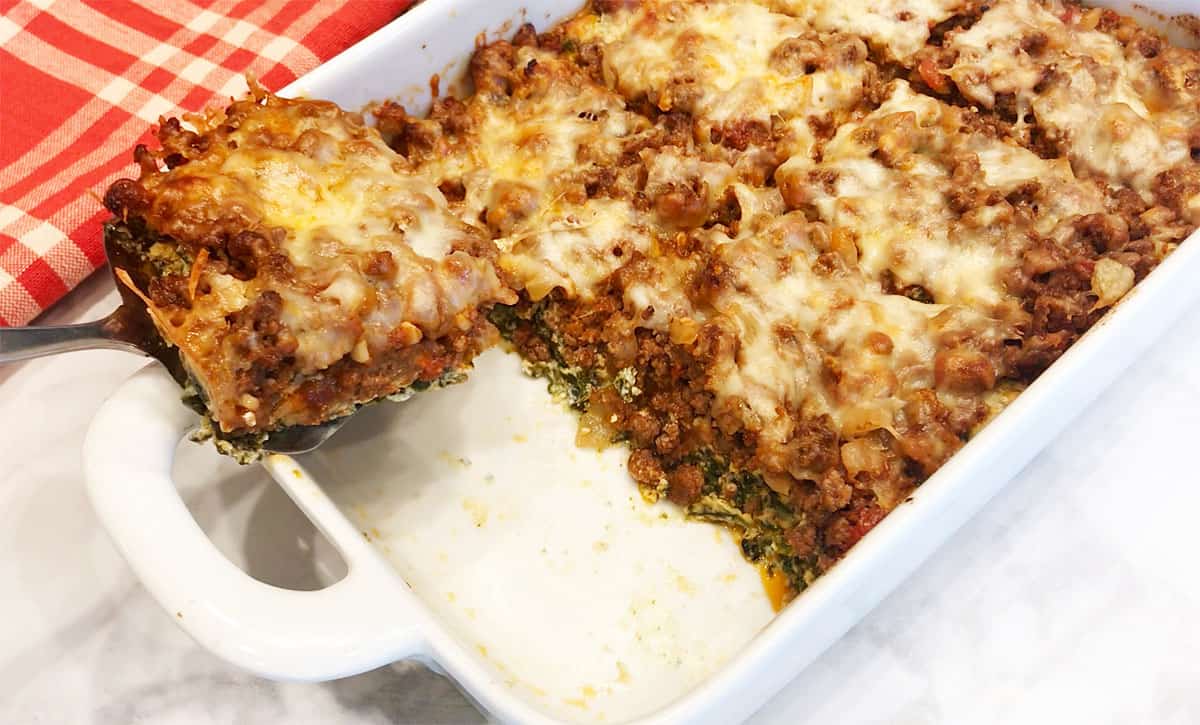 The lasagna is sliced and served.