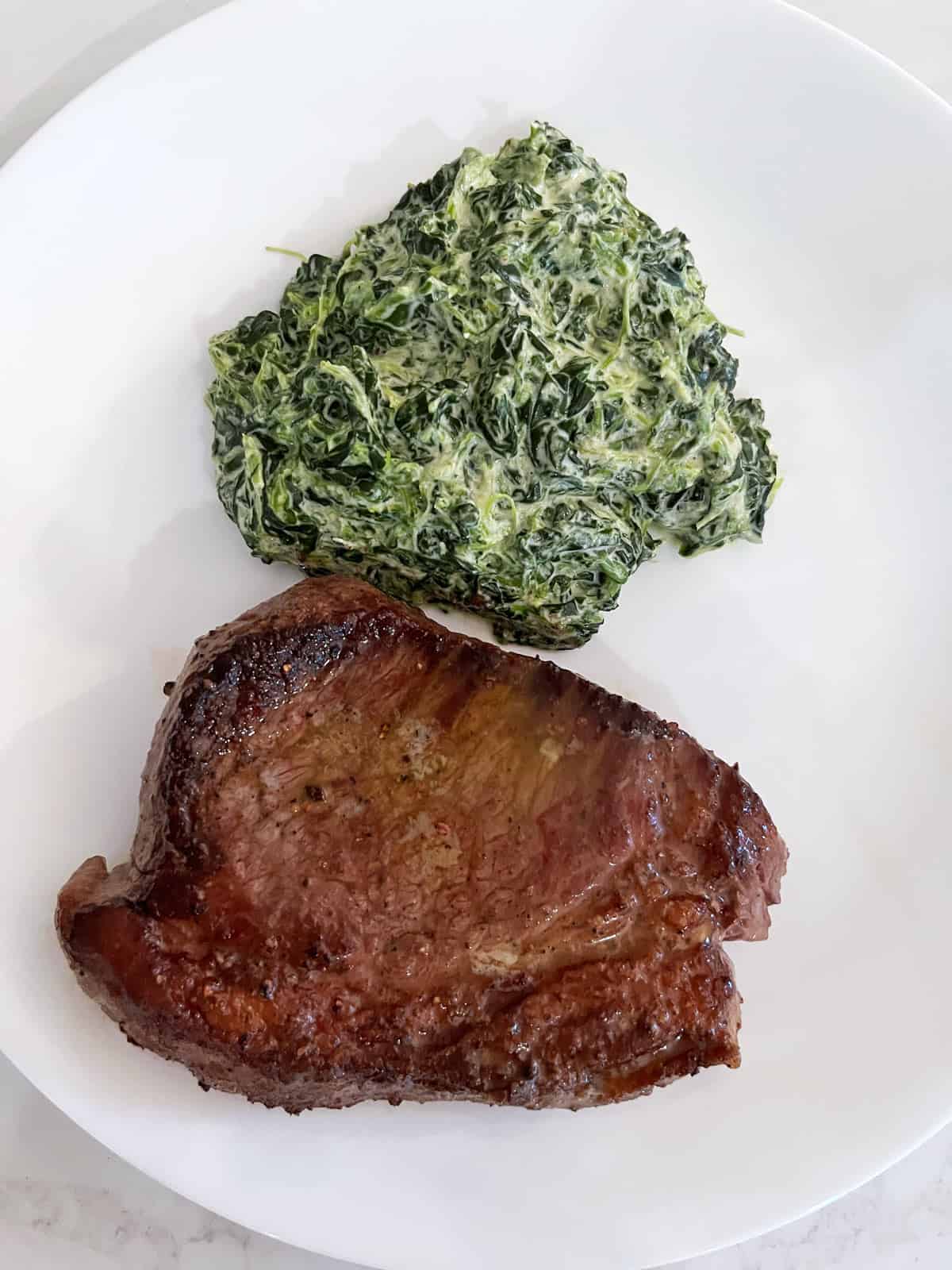 Leftover picanha steak, reheated and served with creamed spinach.