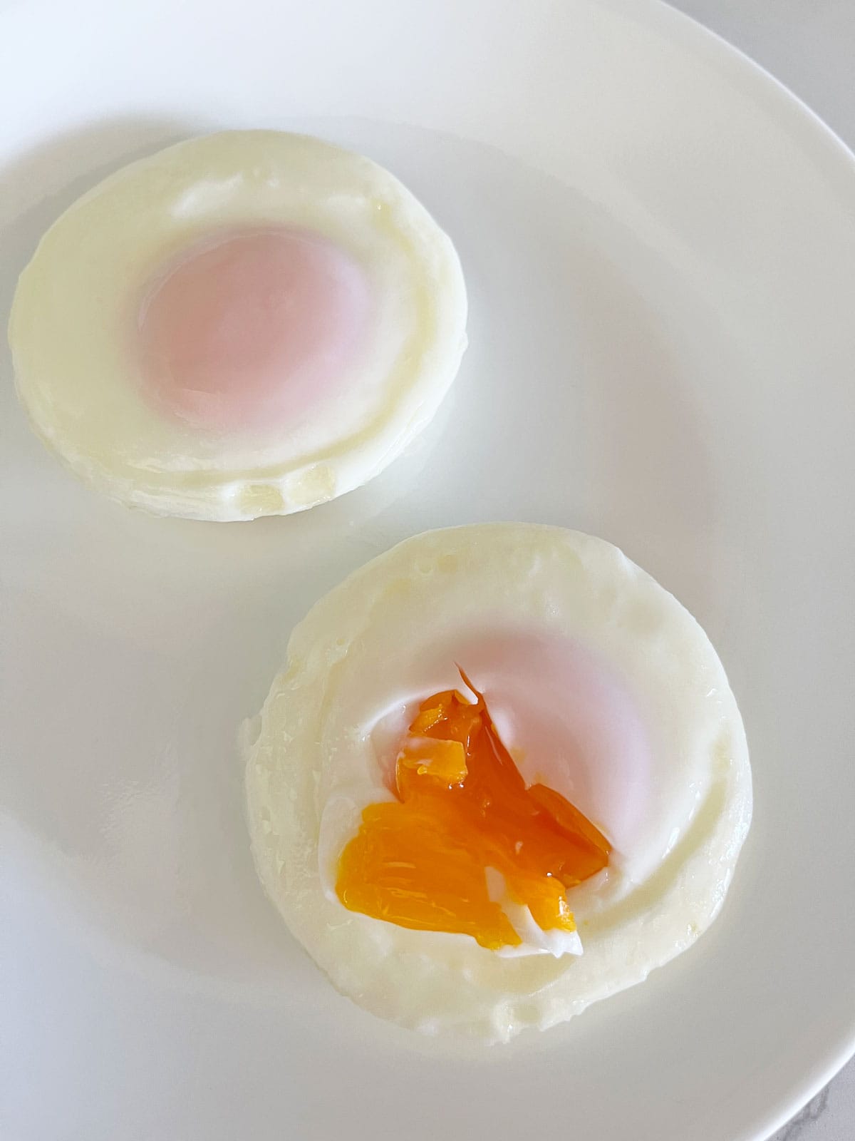 Two eggs that were poached in a stovetop egg poached for four minutes.