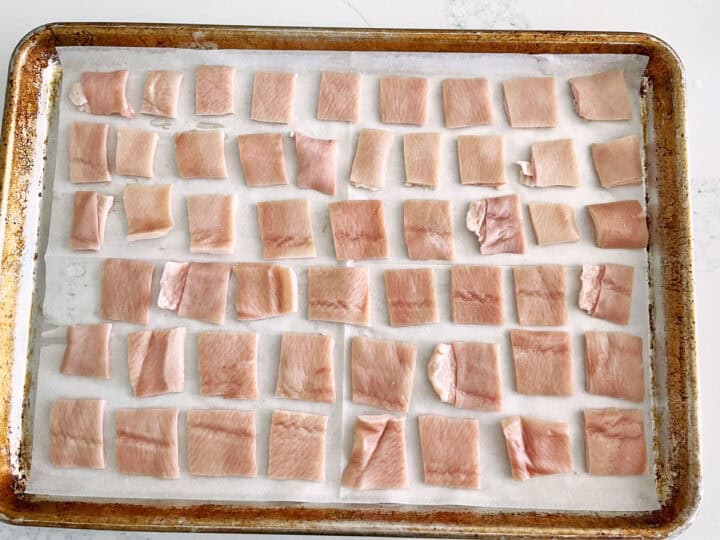 Pork skin squares are arranged in the pan.