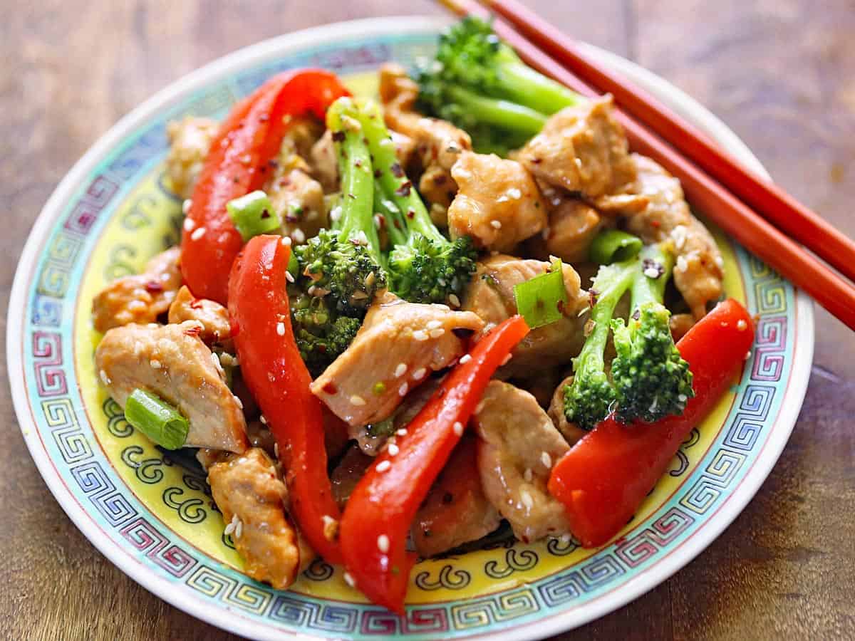 A pork stir-fry is served on a Chinese dinner plate.
