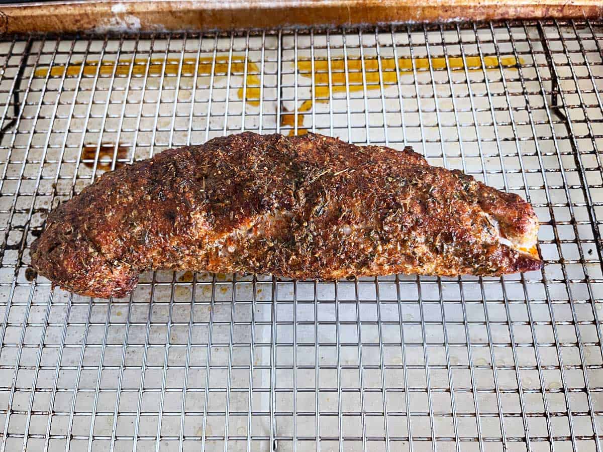 Roasted pork tenderloin is ready on the baking sheet.