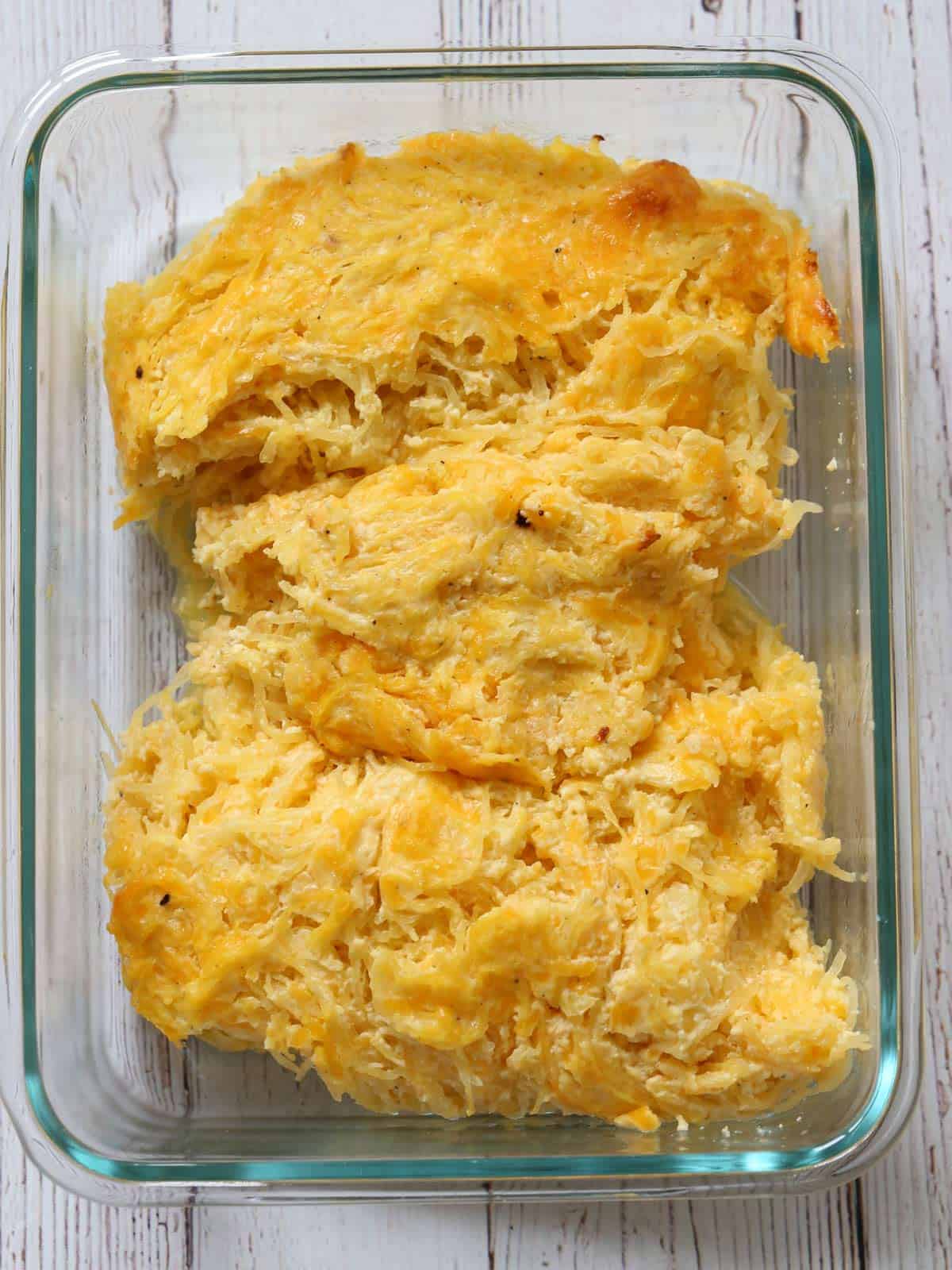 Leftover spaghetti squash casserole is kept in a glass food storage container.