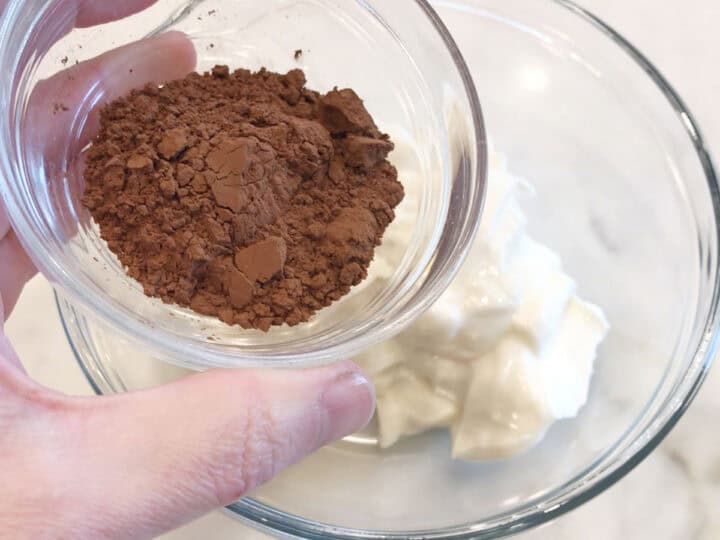 Adding cocoa powder to the yogurt.