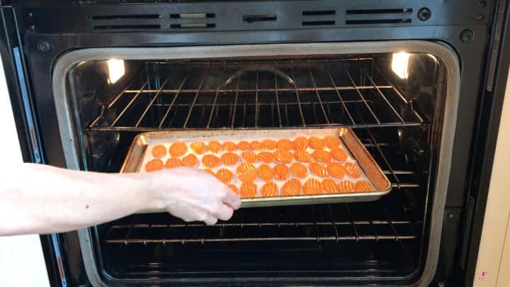 Placing the carrot slices in the oven.