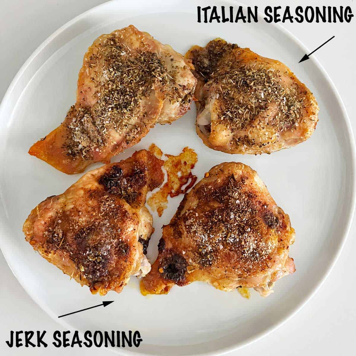 Four crispy chicken thighs on a plate, two with jerk seasoning and two with Italian seasoning.