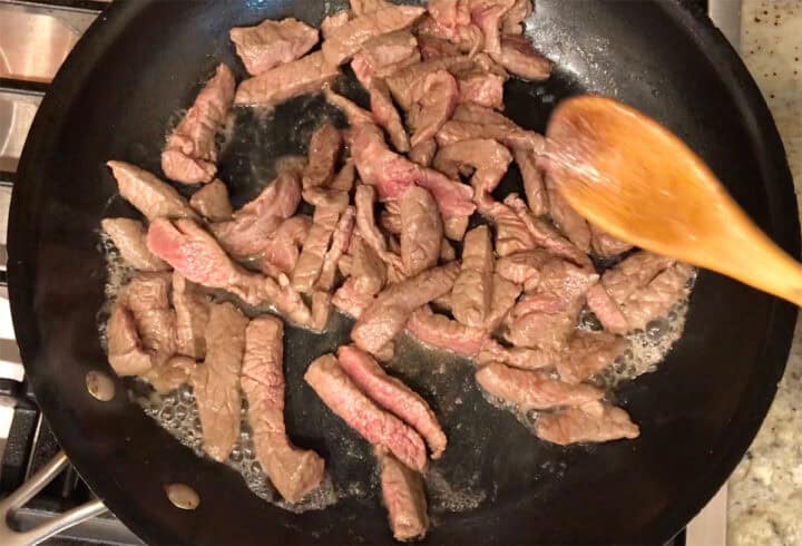 Cooking the beef in the skillet.