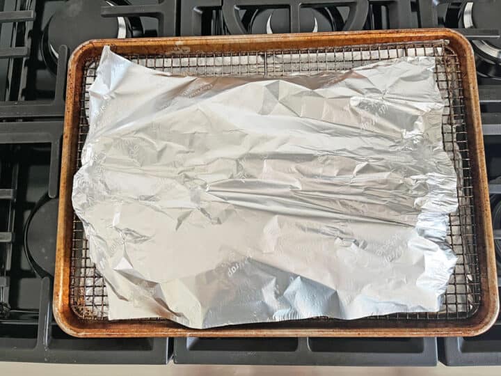 The pork tenderloin is loosely covered with foil before being put back in the oven for ten more minutes.