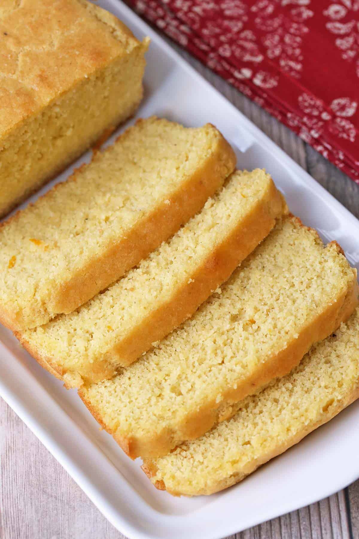 A sliced keto pound cake is served on a white serving tray.