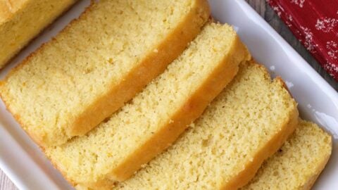 A sliced keto pound cake is served on a white tray.