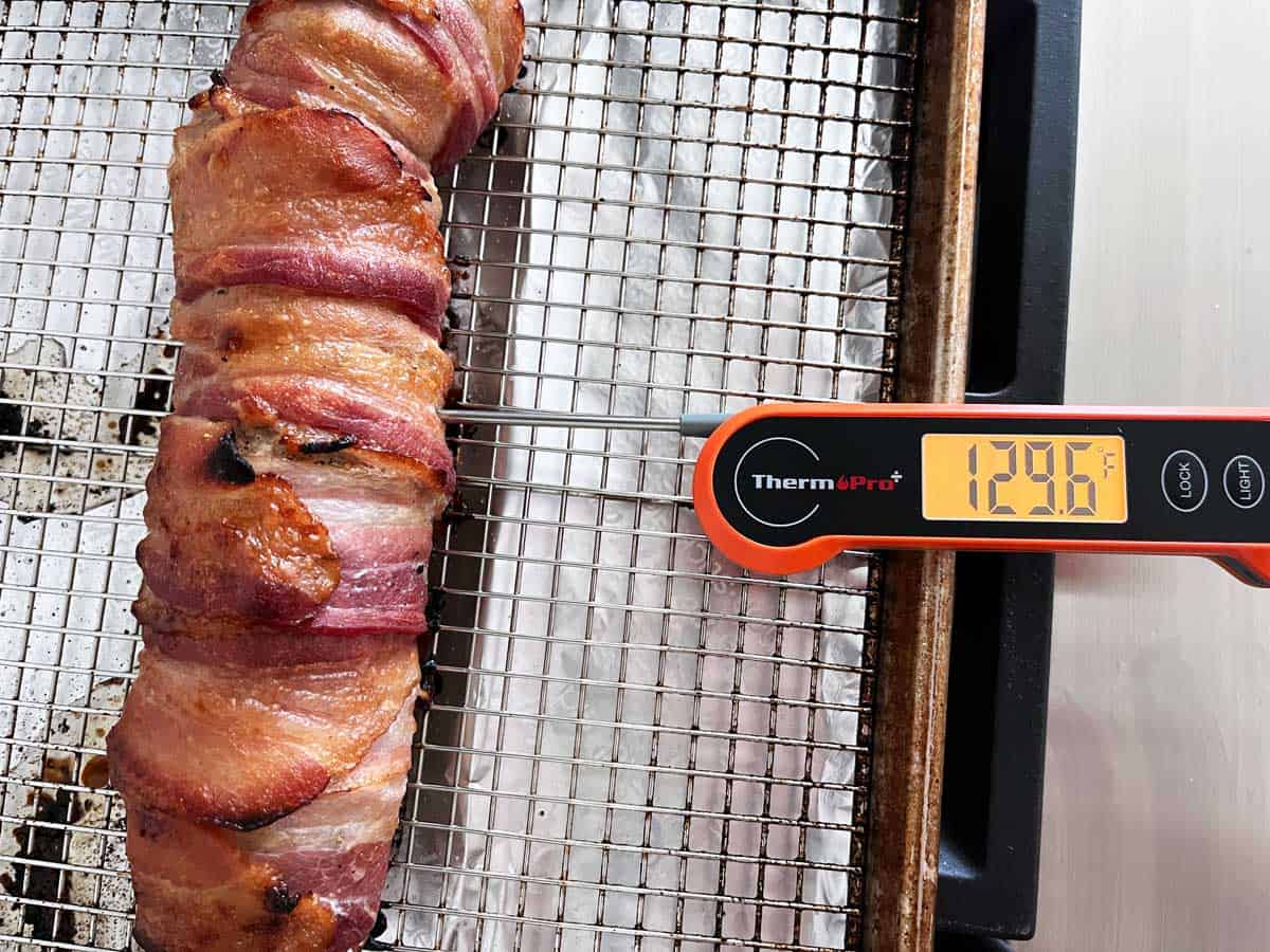 After 30 minutes in the oven, the pork has reached an internal temperature of 129.6°F.