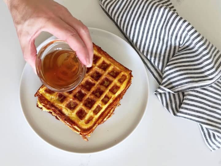 Pouring syrup on top of the chaffles.