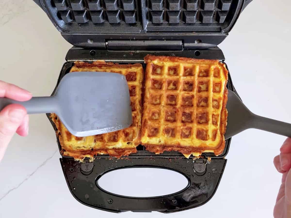 Removing the chaffles from the waffle iron with a wide spatula.
