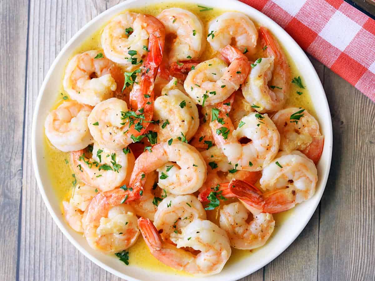 Shrimp scampi is served on a white plate.