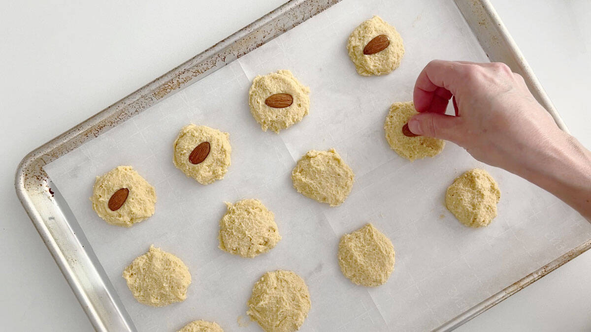 Topping the cookies with almonds.